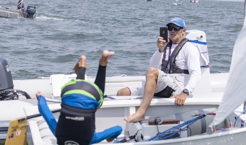 Joel Beashel does a flip into the water to celebrate winning the Australian Optimist Championship, as his father, Adam, watches on (and films it). - photo © Photo supplied