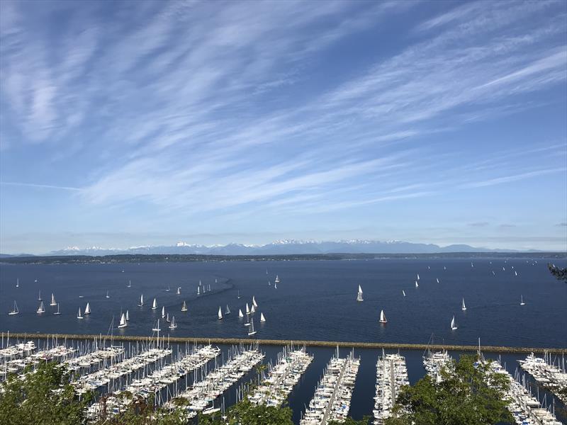 Yachts assemble off of Seattle Shilshole Bay Marina for the start of a distance race under clear skies, with the Olympic Mountains to the west - photo © Coreen Schmidt