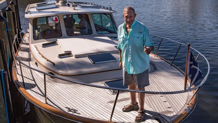 George Cohon stands on the bow of his 48-foot Hinckley named McHappy III photo copyright Christine Davi taken at  and featuring the Power boat class