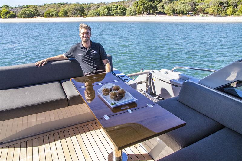 Tom Barry-Cotter in the versatile cockpit with the offset table that can be set for dining table or coffee photo copyright John Curnow taken at  and featuring the Power boat class