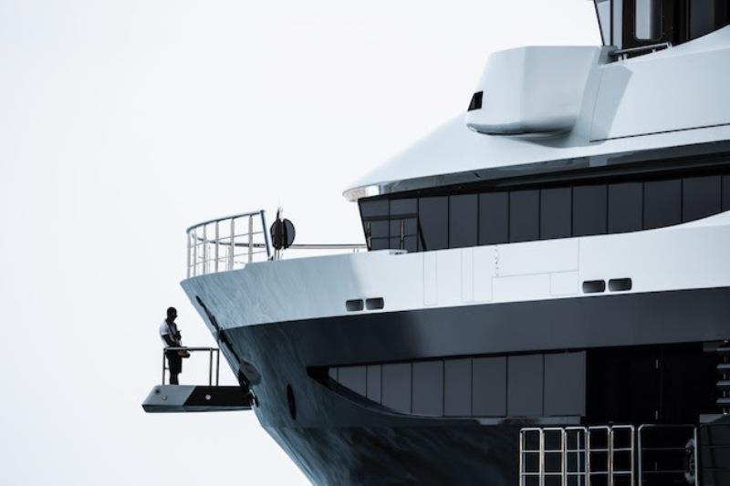 91,5 metres megayacht Tranquility at the anchor in a Med bay. One of her crew controlling the helm from the outside. - photo © Guillaume Plisson