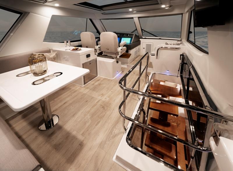 The Riviera 54 Enclosed Flybridge includes a forward helm on the port side and an L-shape lounge around a table with integrated drink holders aft. - photo © Riviera Australia