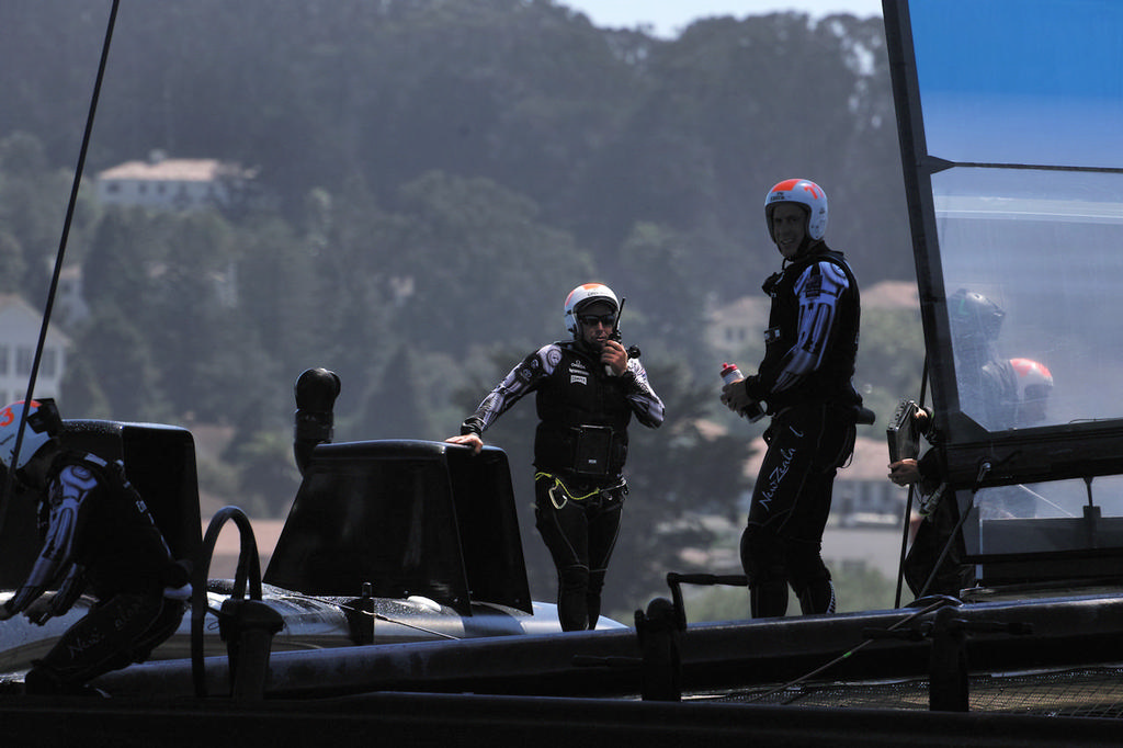 Emirates TNZ crew prepares for race 2, standing next to the new 