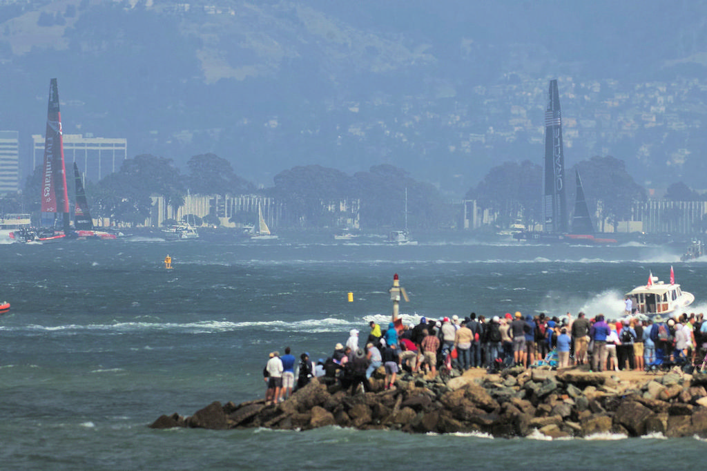 Fans on the rock jetty watch Oracle winning race four. - America’s Cup © Chuck Lantz http://www.ChuckLantz.com