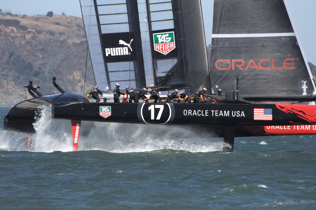 Crewman John Kostecki is the first to move across to the new side as Oracle gybes. - America’s Cup © Chuck Lantz http://www.ChuckLantz.com