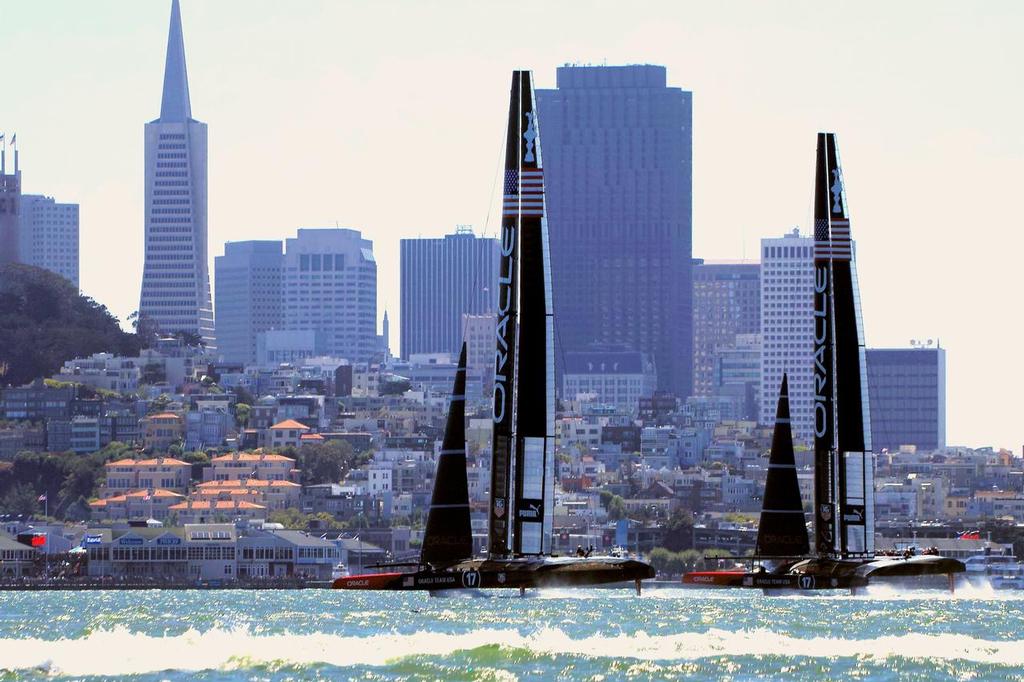 Boat two leads boat one, flying past the TransAmerica Pyramid building. - America’s Cup 2013 © Chuck Lantz http://www.ChuckLantz.com