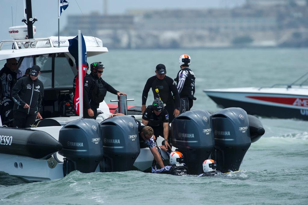 Rob Waddell and Chris Ward are recovered after going over board when Emirates Team New Zealand bury the bows in the bear away at the top mark in their first race of the Louis Vuitton finals against Luna Rossa Challenge. .17/8/2013 © Chris Cameron/ETNZ http://www.chriscameron.co.nz