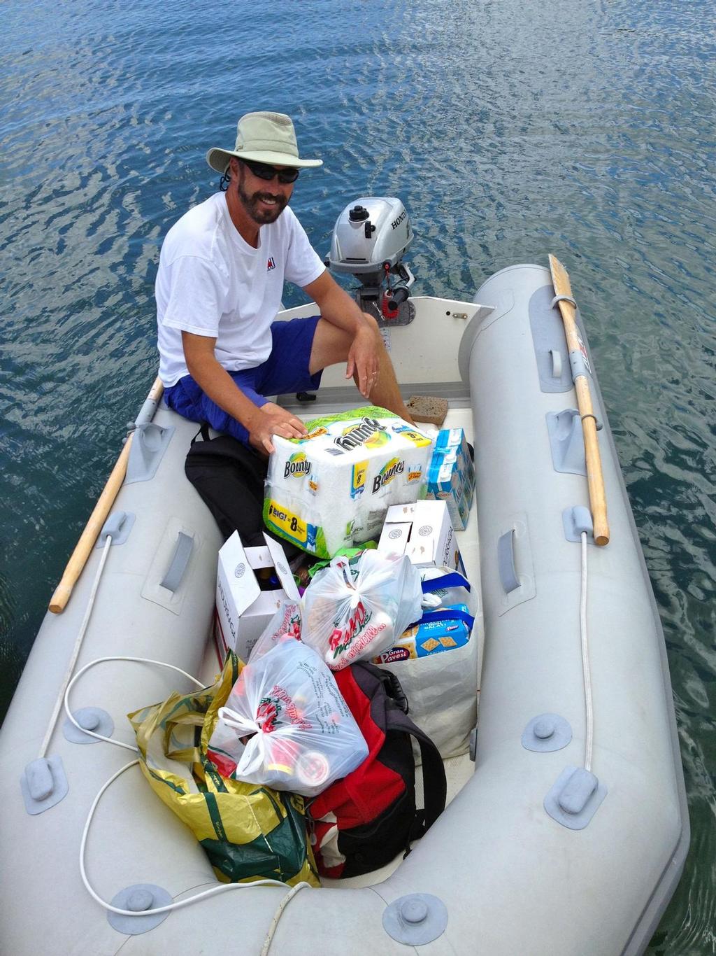 Paul Shard with a dinghy-load of provisions heading back to the boat. © Sheryl Shard