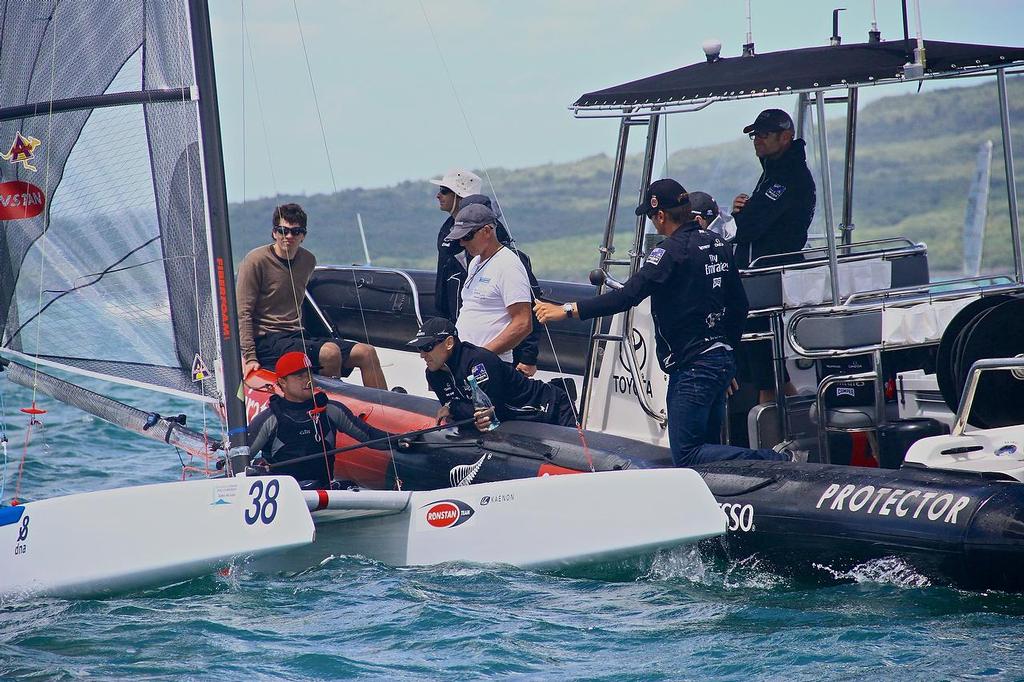 Glenn Ashby checks in with the Emirates Team NZ chase boat, talking with Kevin Shoebridge, Dean Barker holding the forestay. A-class catamaran World Championships, Day 2, Takapuna February 12, 2014 © Richard Gladwell www.photosport.co.nz