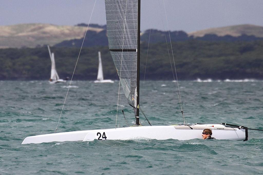 Peter Burling (NZL) swimming in Race 6, final leg, trying to clear a foil issue. A-class catamaran World Championships, Day 3, Takapuna February 13, 2014 photo copyright Richard Gladwell www.photosport.co.nz taken at  and featuring the  class