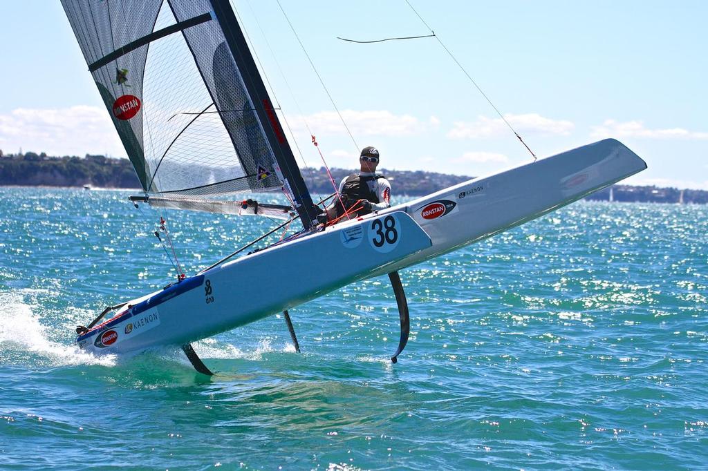 Glenn Ashby does a foil jump as he crosses the finish line to win the 2014 Int. A-Class Catamaran Worlds, Takapuna, NZ He has won nine world titles in the now foiling singlehander. photo copyright Richard Gladwell www.photosport.co.nz taken at  and featuring the  class