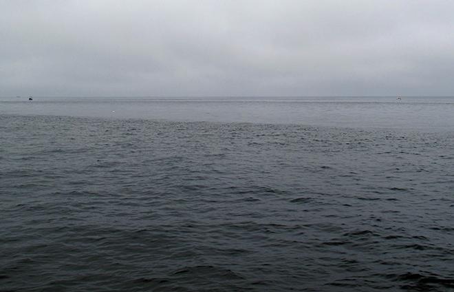 In search of internal waves, scientists look for alternating bands of rough water and slicks of smooth water on the ocean surface. The rough water forms when when internal waves move upward within the ocean; the smooth slicks form when internal waves move downward.  © Leslie Baehr WHOI