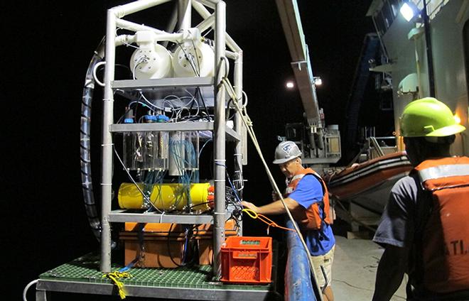 Atlantis Bosun Patrick Hennessey and Ordinary Seaman Clindor Chacho begin to lower Vent-SID to the seafloor via a wire. © Jennifer Barone