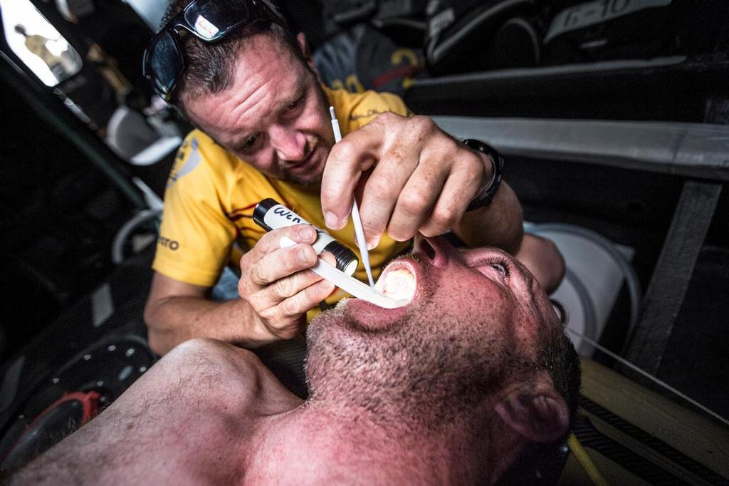 December 01, 2014. Leg 2 onboard Abu Dhabi Ocean Racing. Dr. Wendy Harmer is at it again this time repairing a sensitive tooth on Justin Slattery.  Temporary filling work in the bow while floating along in the Doldrums. © Matt Knighton/Abu Dhabi Ocean Racing