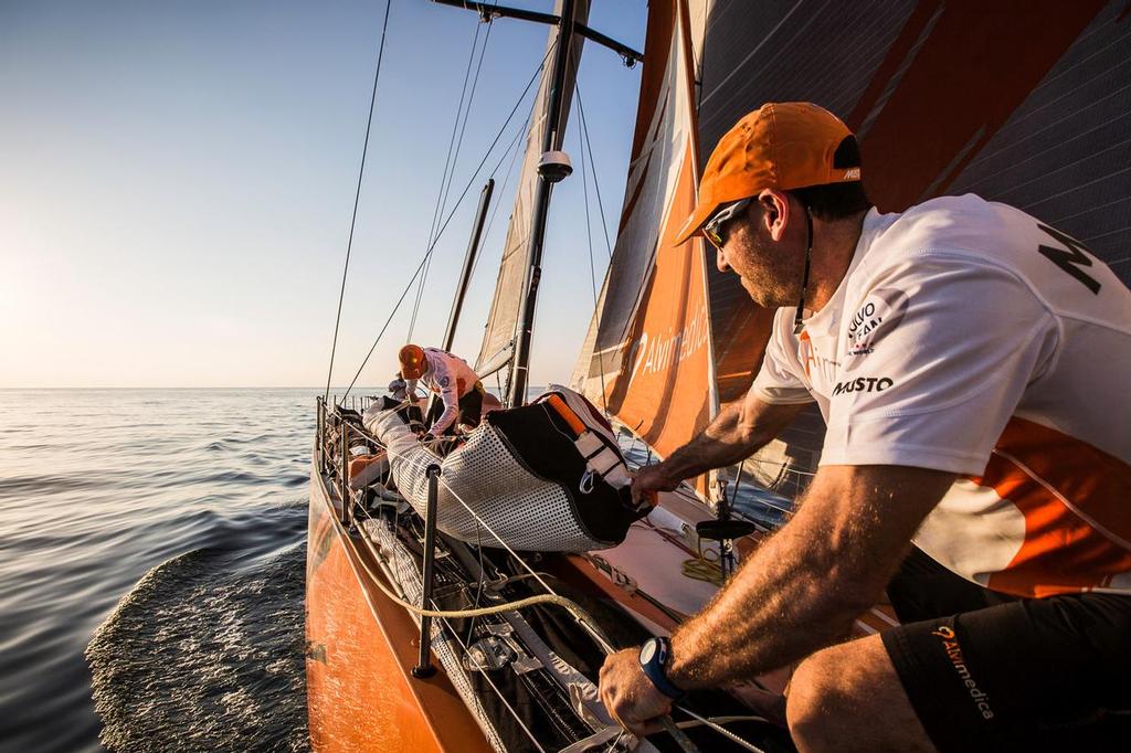 January 5, 2015. Leg 3 onboard Team Alvimedica. Day 2. The close sailing east through the Straits of Hormuz continues, and the fleet enters the Gulf on it's way towards India. Seb Marsset pulls a jib and it's extra weight forward on to the bow. photo copyright Volvo Ocean Race http://www.volvooceanrace.com taken at  and featuring the  class