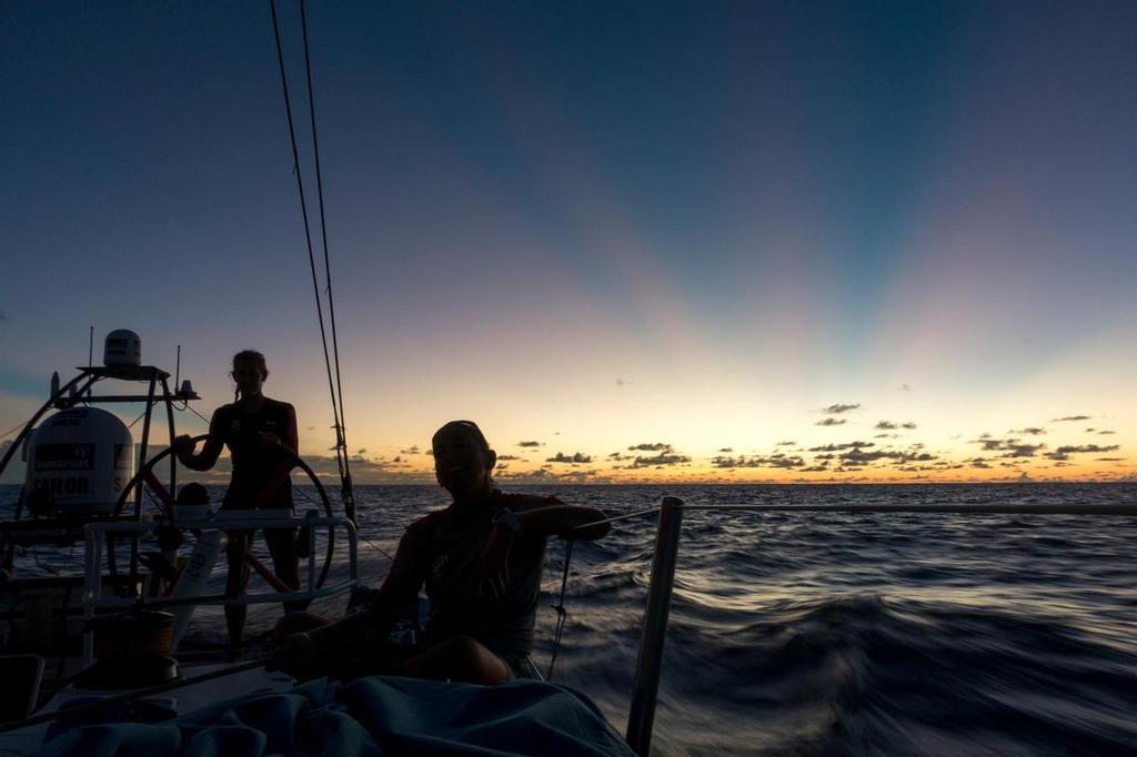 December 04, 2014. Leg 2 onboard Team SCA. Sophie Ciszek helms at sunset while Dee Caffari trims the A3. © Corinna Halloran / Team SCA