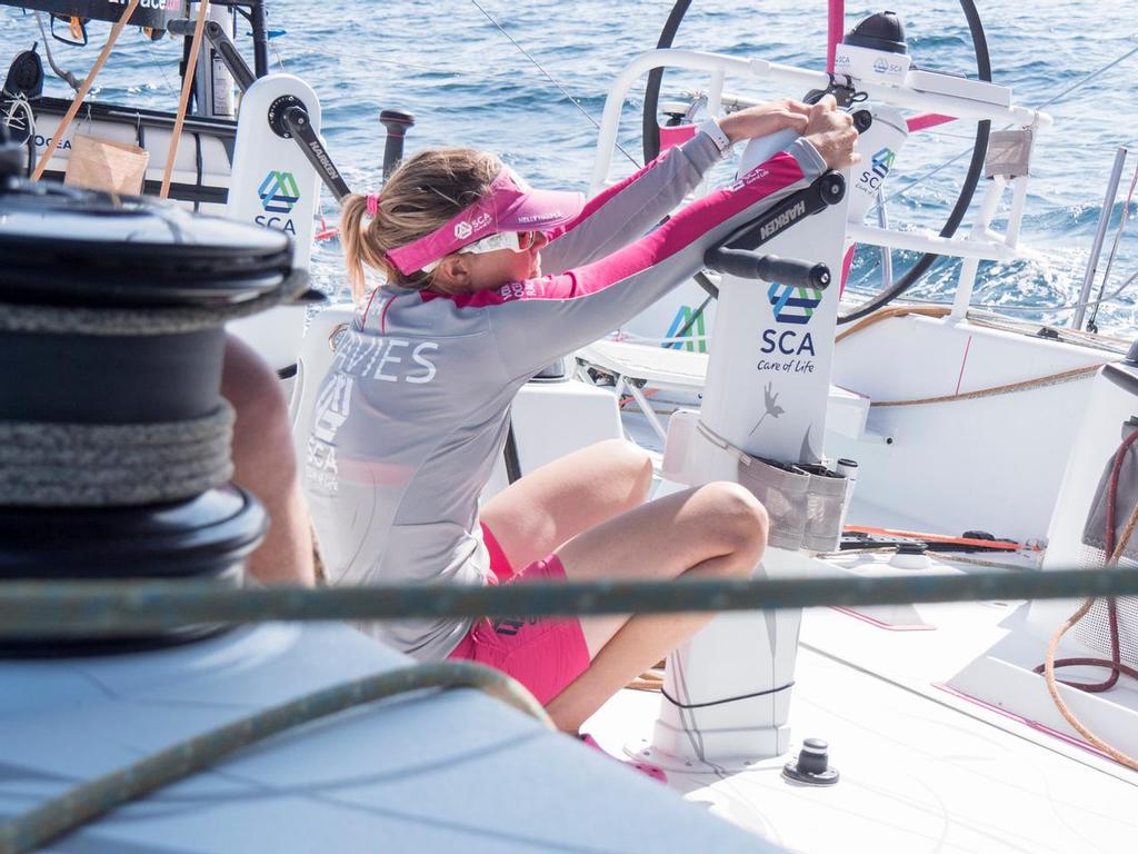 December 11, 2014. Leg 2 onboard Team SCA. Sam Davies takes a minute from grinding to stretch her back and arms. © Corinna Halloran / Team SCA