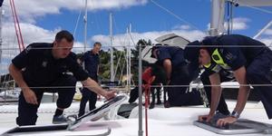 Thorough: A Ministry of Primary Industry ``rummaging crew``, backed up by detector dog Snoop, inspect a catamaran arriving at Opua. photo copyright MPI NZ taken at  and featuring the  class