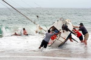 A group of bystanders attempt, unsuccessfully, to manoeuvre the yacht back into the water at Stanwell Park Beach on Sunday. photo copyright Sylvia Liber taken at  and featuring the  class