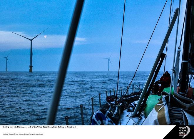 Sailing past wind farms, on leg eight of Volvo Ocean Race, from Galway to Masrstrand. - Volvo Ocean Race 2014-15 © Guo Chuan/Green Dragon Racing/Volvo Ocean Race http://www.volvooceanrace.org