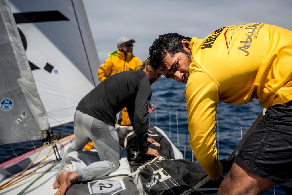 October 30, 2014. Leg 1 onboard Abu Dhabi Ocean Racing. Adil khalid and Luke Parkinson securing the sails to the deck to stabilise the weight distribution and to prevent any potential damage to the sails or boat. © Matt Knighton/Abu Dhabi Ocean Racing