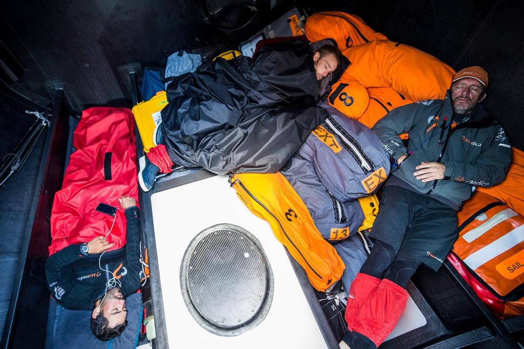 November 4, 2014. Leg 1 onboard Team Alvimedica. Day 24. With just 650 miles to Cape Town, the sailing slows considerably as a high-pressure system moves in from the west. Mark Towill (L), Nick Dana (M), and Will Oxley (R) try for sleep in the bow while winds are light. ©  Amory Ross / Team Alvimedica