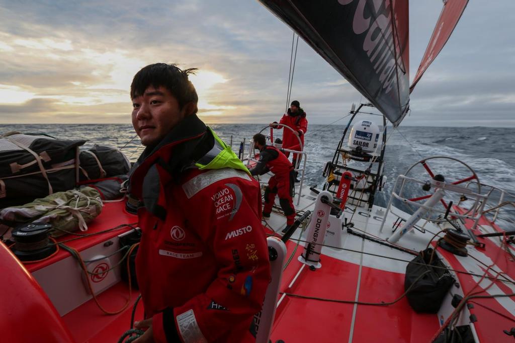 November 2, 2014. Leg 1 onboard Dongfeng Race Team. Jiru Yang, Wolf, onboard during a sunset in the Roaring 40s. © Yann Riou / Dongfeng Race Team