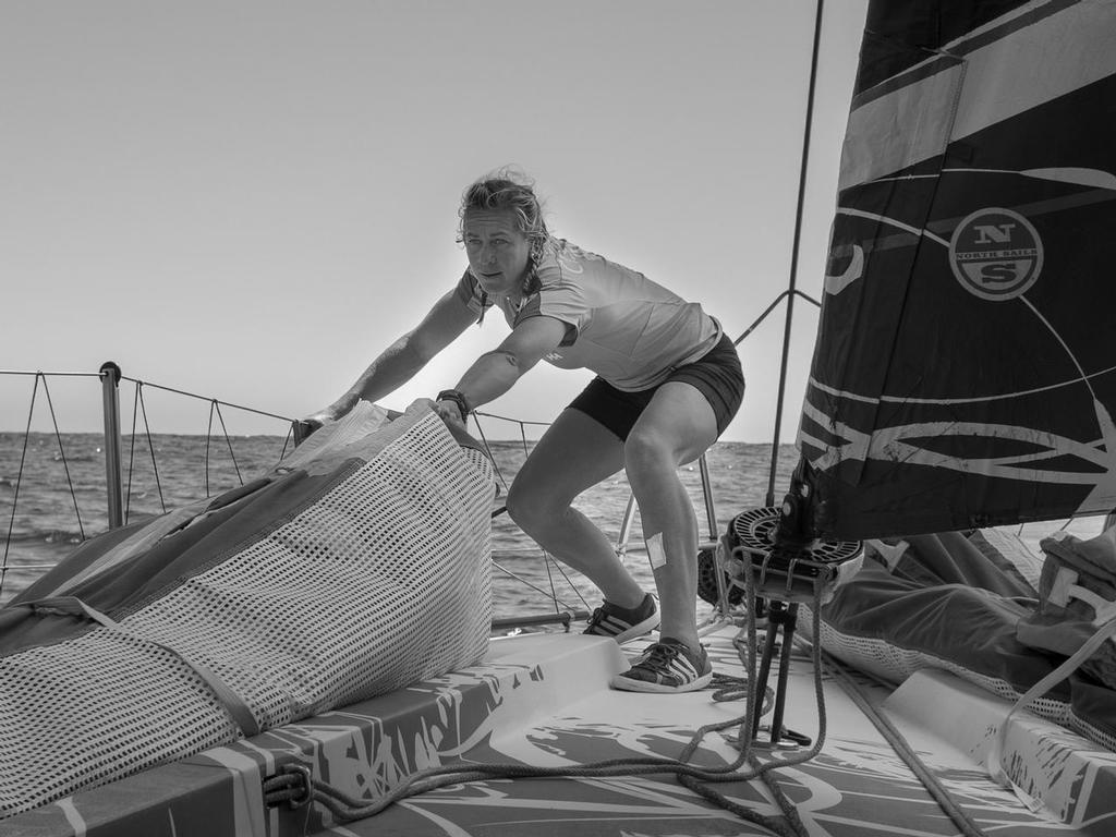 October, 2014. Leg one onboard Team SCA. Sophie Ciszek helps pull the sail forward on the bow. © Corinna Halloran / Team SCA
