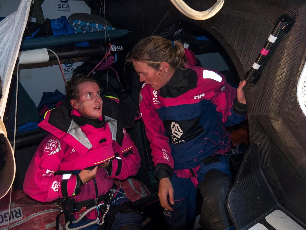 November 06, 2014. Leg 1 onboard Team SCA. Stacey Jackson and Carolijn Brouwer get dressed in their wet weather gear. © Corinna Halloran / Team SCA