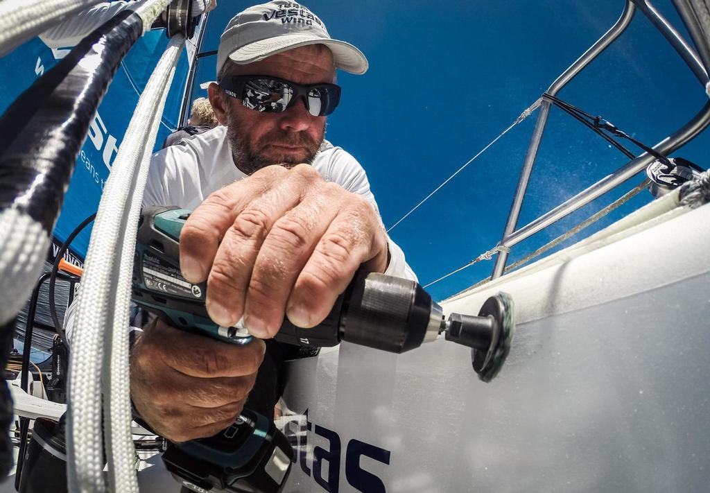 October 30, 2014. Leg 1 onboard Team Vestas Wind. Chris Nicholson gets to grips with some power tools. Time to sand the decks to protect the runners from chaff.  © Brian Carlin - Team Vestas Wind