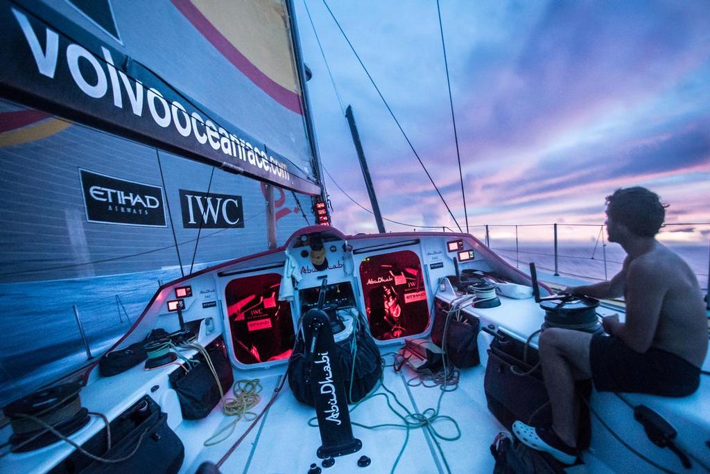  Leg 4 to Auckland onboard Abu Dhabi Ocean Racing. Day 15. Roberto Bermudez ’Chuny’ sits along on his watch as the fires in the sky kick into gear as the team heads for hopefully the last of the rain squalls at dusk in the Doldrums. © Matt Knighton/Abu Dhabi Ocean Racing