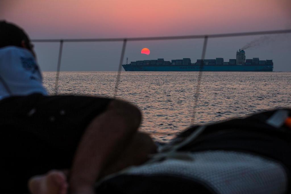 January 4, 2015. Leg 3 onboard Team Alvimedica. Day 1. Winds dissipate as the temperatures rise in the Straits of Hormuz. A Maersk Line container ship passes at sunset in the Straits of Hormuz. ©  Amory Ross / Team Alvimedica