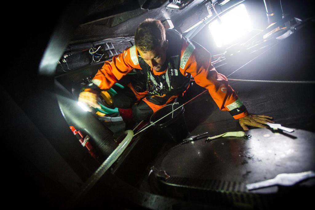 February 10, 2015. Leg 4 to Auckland onboard Team Alvimedica. Day 2. Nick Dana looks for water to bail in the aft watertight bulkhead, a frequent victim to water ingression. ©  Amory Ross / Team Alvimedica