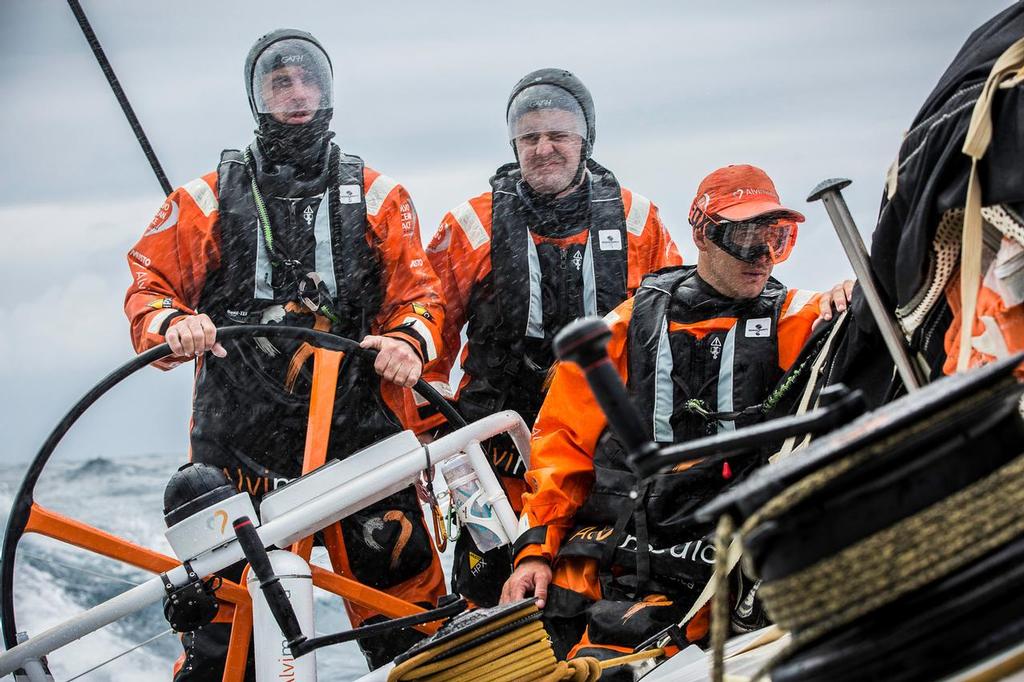 February 10, 2015. Leg 4 to Auckland onboard Team Alvimedica. Day 2. Seb Marsset (L), Ryan Houston (M), and Nick Dana (R) wear various measures of protection against the near-constant spray in the rough upwind conditions. ©  Amory Ross / Team Alvimedica
