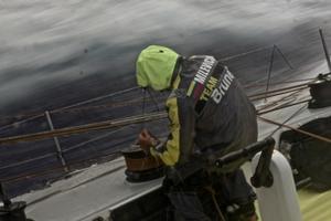 Rokas Milevicius trims the sail while the team sail through a heavy rain cloud - Volvo Ocean Race 2014-15 photo copyright Stefan Coppers/Team Brunel taken at  and featuring the  class