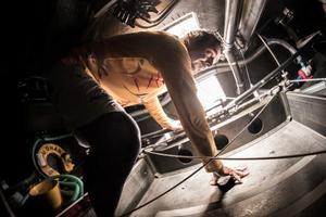 onboard Abu Dhabi Ocean Racing. Roberto Bermudez 'Chuny' climbs out of the aft compartment after bailing out the leeward bilge - Volvo Ocean Race 2014-15 photo copyright Matt Knighton/Abu Dhabi Ocean Racing taken at  and featuring the  class