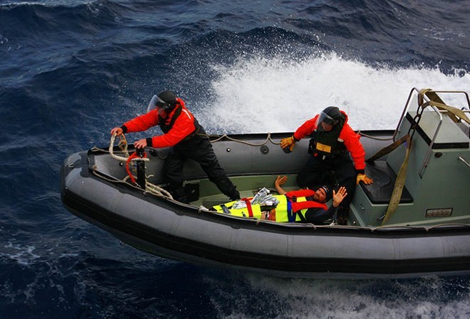 French solo yatchsman, Yann Elies, waves to sailors on the starboard waist of HMAS Arunta as the ships rigid hull inflatable boat pulls alongside preparing to transfer him to the ship for evacuation. Photography by Able Seaman Photographer Lincoln Commane.<br />
 © Commonwealth of Australia