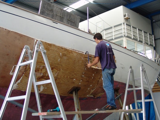 Boatbuilders have already started stripping away the plywood protection patch on the exterior of the hull © Richard Gladwell www.photosport.co.nz