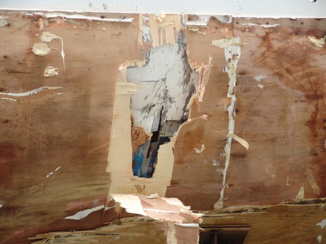 First of the plywood patch is removed showing the damaged hull underneath © Richard Gladwell www.photosport.co.nz