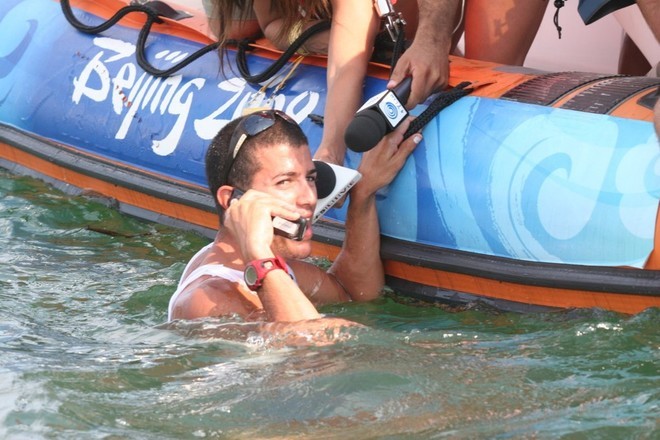 An elated Shahar Zubari (ISR) phone home just minutes after winning the Bronze medal in the RS:X Mens © Richard Gladwell www.photosport.co.nz