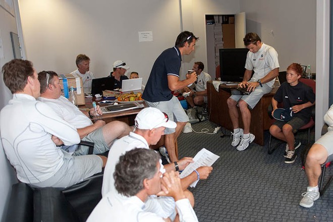 Oscar joins a crew briefing before Practice. That’s former world Star Champion, Hamish Pepper (NZL) standing in the blue shirt, and Hamish Wilcox (NZL), triple world 470 champion and 2008 GBR Olympic coach seated in the white peaked cap.   © BMW Oracle Racing Photo Gilles Martin-Raget http://www.bmworacleracing.com