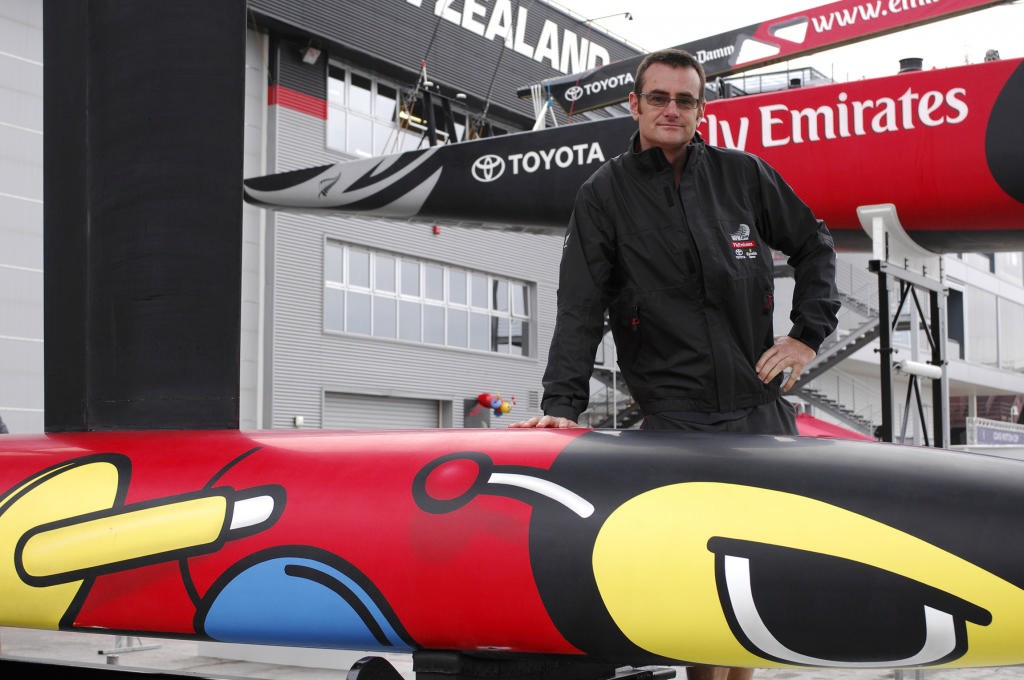 Emirates Team New Zealand designer Nick Holroyd leans on the Buzzy Bee bulb attached to NZL84 on unveiling day. © Emirates Team New Zealand / Photo Chris Cameron ETNZ 