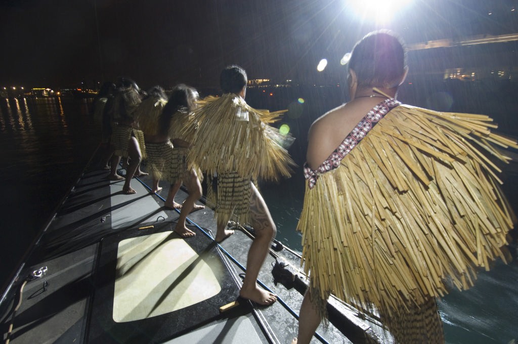 Maori Warriors do a Haka on the bow of NZL84 as Emirates Team New Zealand pass the Vent and Velas building in the opening ceremony boat parade.  © Emirates Team New Zealand / Photo Chris Cameron ETNZ 