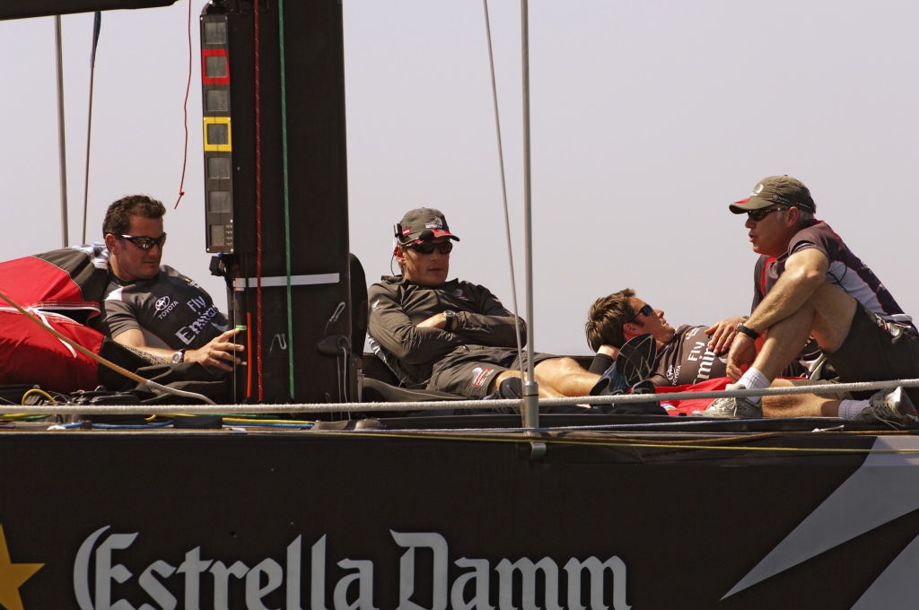 Emirates Team New Zealand crew Barry McKay, Dean Barker, Richard Meacham and Don Cowie sit on the foredeck of NZL92 waiting for wind that never comes.  © Emirates Team New Zealand / Photo Chris Cameron ETNZ 
