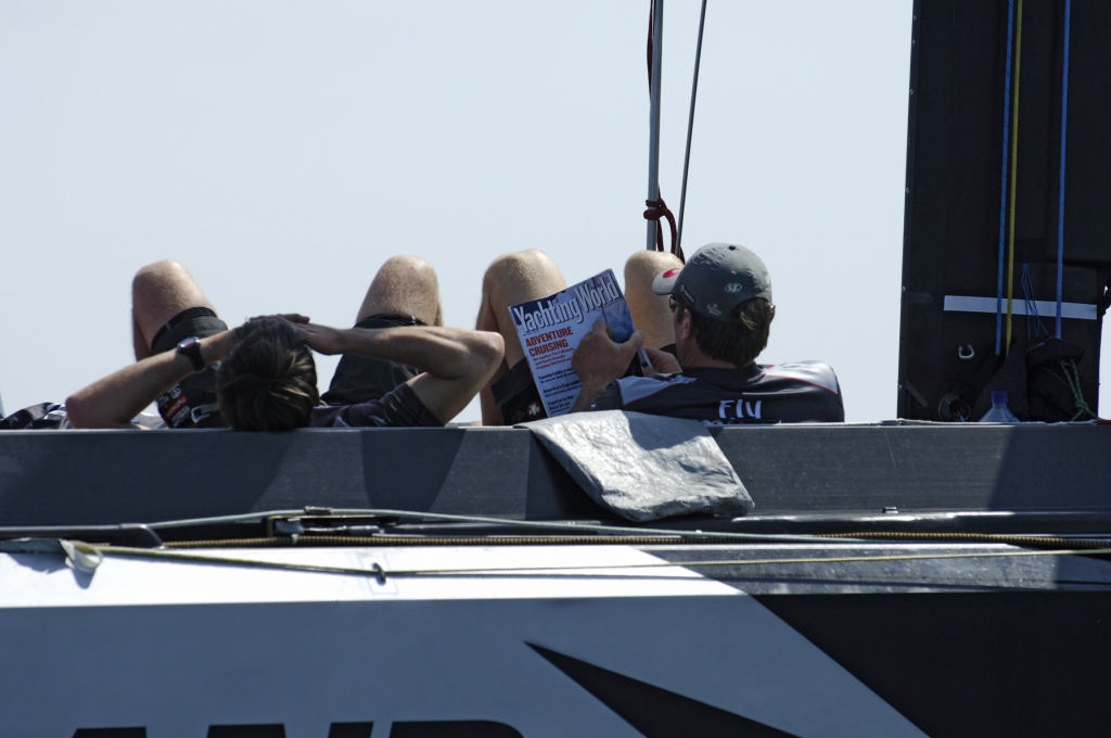 Emirates Team New Zealand sailor Tony Rae reads the latest Yachting World issue while waiting for the wind on day three of the Louis Vuitton Cup. Wind did not eventuate again. photo copyright Emirates Team New Zealand / Photo Chris Cameron ETNZ  taken at  and featuring the  class