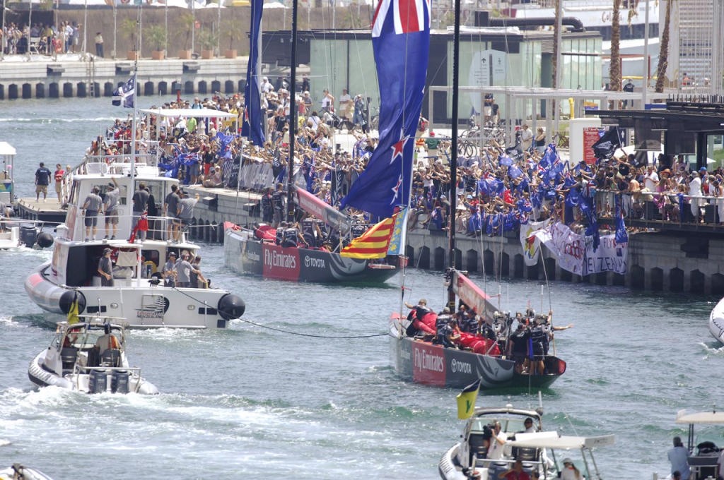 Emirates Team New Zealand NZL84 and NZL92 pass crowds of kiwi fans with flags as they tow out for race two of the America`s Cup. 24/6/2007  © Emirates Team New Zealand / Photo Chris Cameron ETNZ 