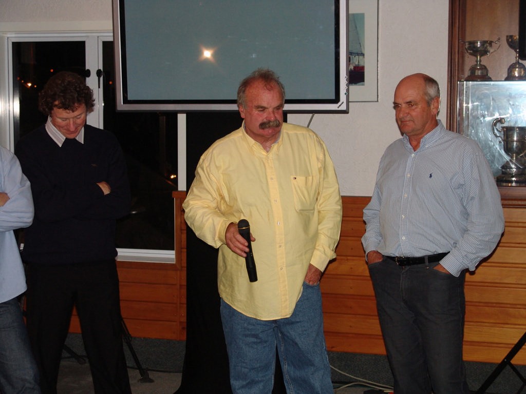 Simon Gundry (centre, yellow shirt) and Richard Macalister (left) and John Newton (right) listen to Pippa Blake speaking from UK - Ceramco dismasting party © Richard Gladwell www.photosport.co.nz