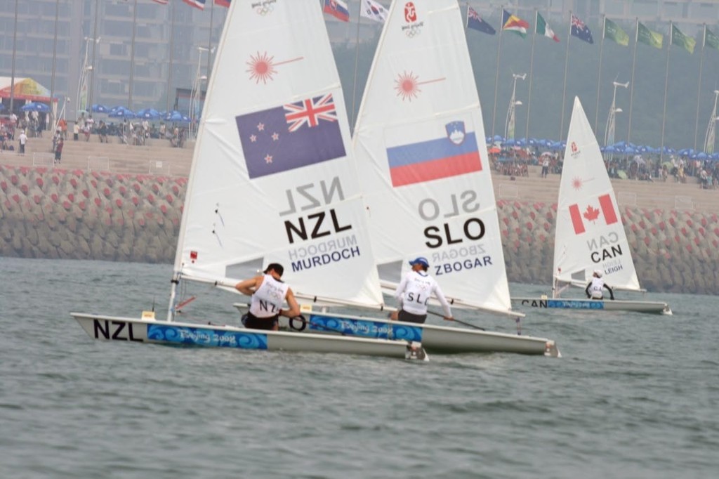 Andrew Murdoch (NZL) goes over the top of Vasilij Zbogar (SLO) on the first geat of the 2008 Olympics Qingdao - Medal Race - Laser © Richard Gladwell www.photosport.co.nz