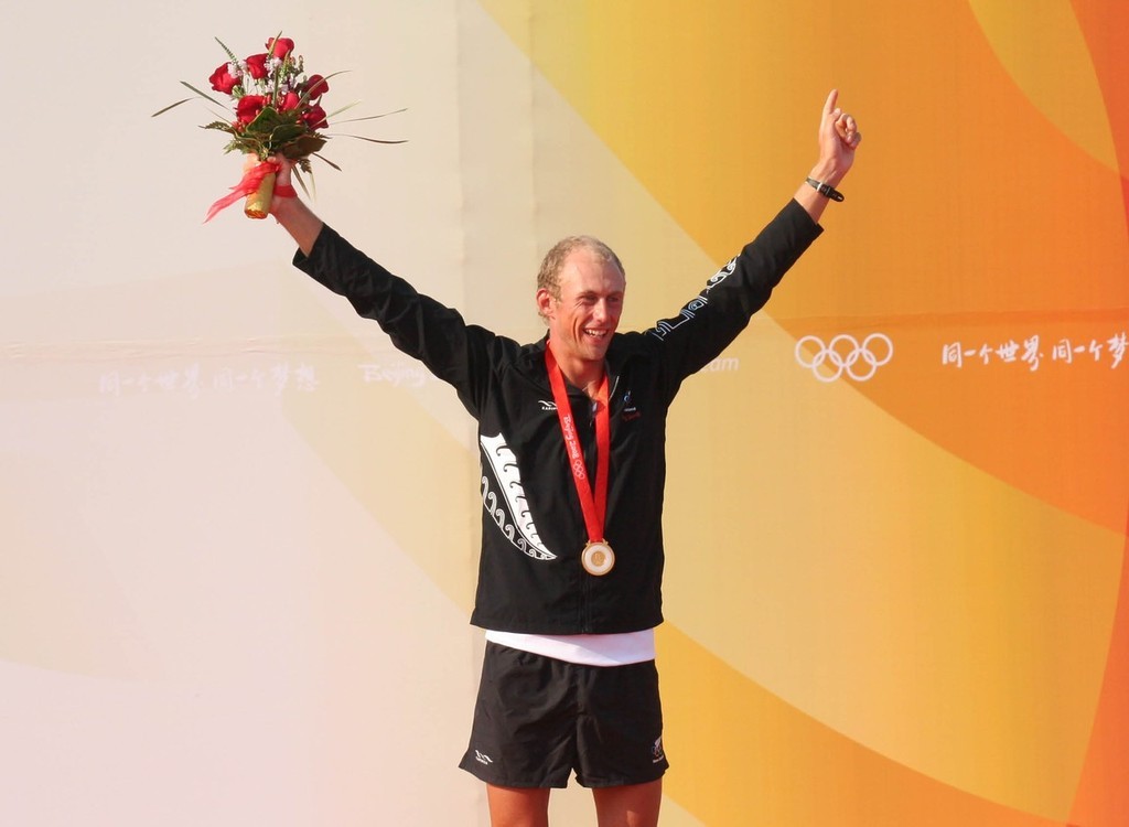 An elated Tom Ashley on the winners podium at the RS:X Mens Medal ceremony Qingdao Olympic Regatta © Richard Gladwell www.photosport.co.nz