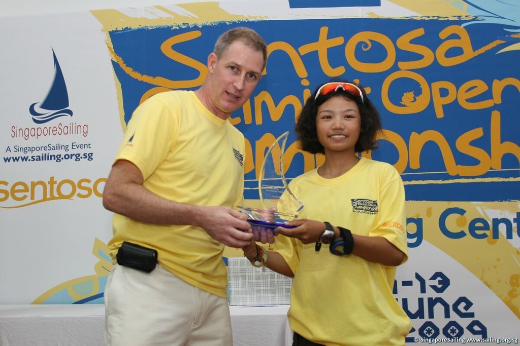 Noppakao Poonpat (THA) receiving the Sentosa Optimist Open Championship Girls Challenge Trophy from Mr Andrew Sanders, CEO of SingaporeSailing (left). © SingaporeSailing